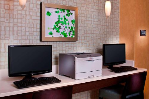 a desk with two computer monitors and a printer at Sonesta ES Suites Birmingham Homewood in Birmingham