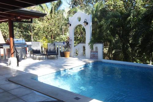 a swimming pool in a yard with two chairs at Casa Vitality Nosara in Nosara