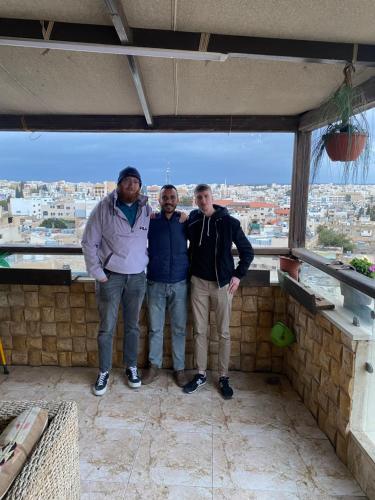 three men posing for a picture on top of a building at MiaDa’bia in Madaba