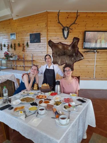 um grupo de pessoas sentadas à mesa com comida em Kungut Hotel & Restaurant em Sheki