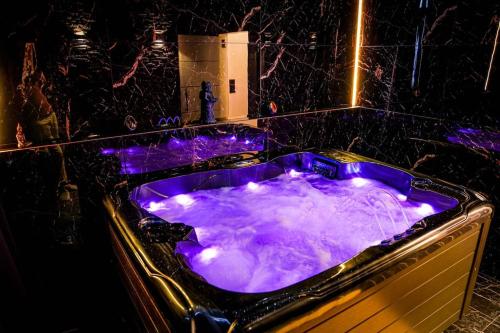 a purple bath tub with purple lights in a bathroom at Logement privé avec Jacuzzi haut de gamme ! près de l'Aéroport de Charleroi in Charleroi