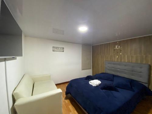 a bedroom with a blue bed and a chair at Apartaestudio calido y bien ubicado en Manizales in Manizales