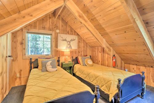 two beds in a room with wooden walls at Alma Cloud 9 Cabin with Fireplace and Wooded Views! in Alma