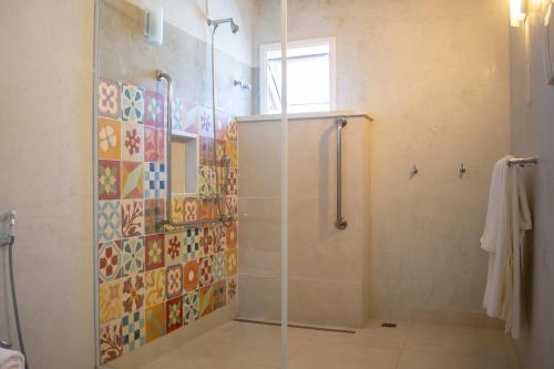 a bathroom with a shower with a glass door at Pousada da Cyssa in Búzios