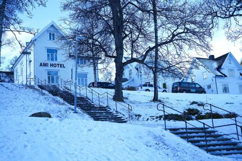 a white building with stairs in the snow at Ami Hotel in Tromsø