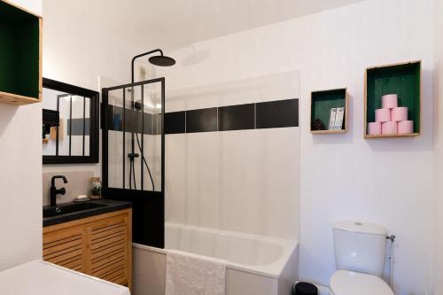 uma casa de banho com um chuveiro, um WC e um lavatório. em Appartement cosy em Biscarrosse