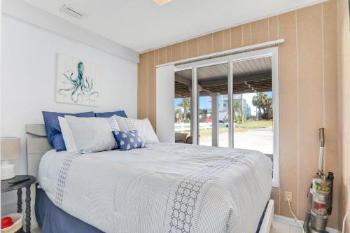 a bedroom with a bed with blue and white pillows at Vilano Beach Oasis Bungalow in St. Augustine