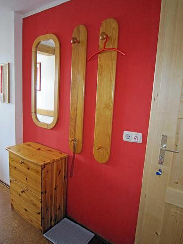 a red wall with wooden snowboards on a wall at Landurlaub Wittmann in Pegnitz