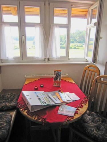 a table with a red table cloth on it with windows at Landurlaub Wittmann in Pegnitz