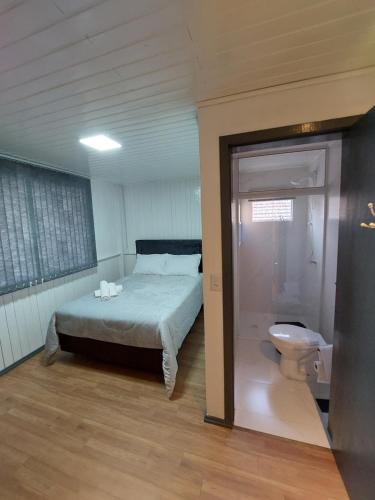 - une chambre avec un lit et des toilettes dans l'établissement Pousada Caminho do Altos, à Bom Jardim da Serra