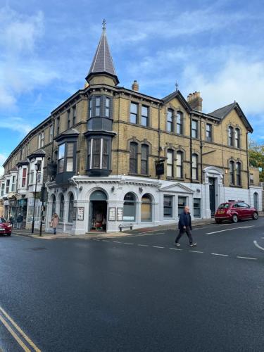 a man crossing a street in front of a building at PENTHOUSE in Shanklin