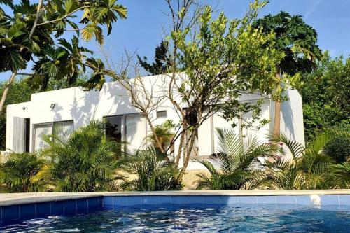 a white house with a swimming pool in front of it at Casa de campo en Turbaco Mi Favorita in Turbaco
