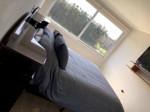 a bedroom with a bed and a window at Moderna casa nueva en hermosa y soleada parcela in La Serena