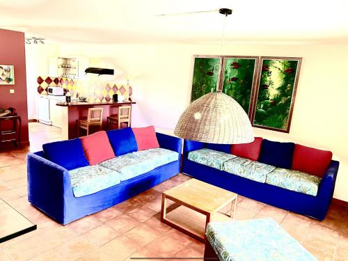 een woonkamer met een blauwe bank en een tafel bij Marisol les pieds dans l eau in Le Gosier