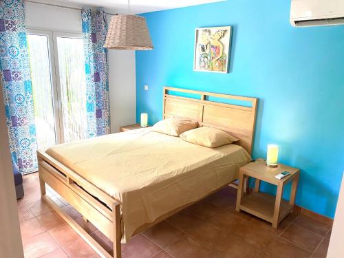 - une chambre dotée d'un lit avec un mur bleu dans l'établissement Marisol les pieds dans l eau, au Gosier