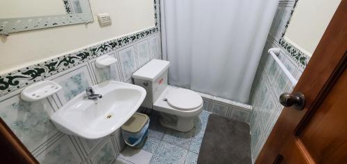 a small bathroom with a toilet and a sink at Departamentos extension Casa Paraíso in Manta