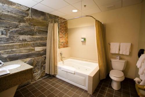 a bathroom with a tub and a toilet and a sink at The Common Man Inn & Restaurant in Claremont