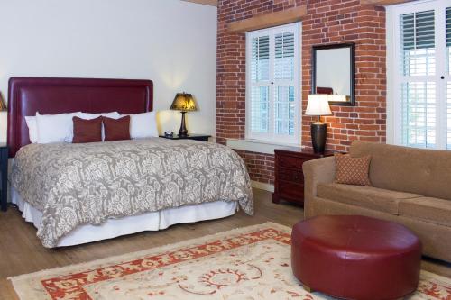 a bedroom with a bed and a brick wall at The Common Man Inn & Restaurant in Claremont