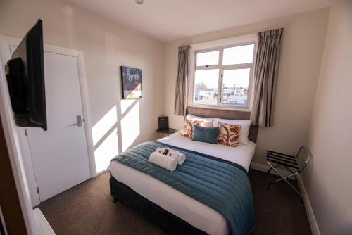 a bedroom with a large bed and a window at The Amberley Hotel in Amberley