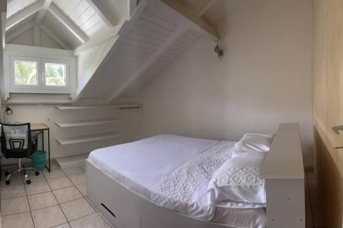 a bedroom with a white bed in a attic at l'escale des roches gravées in Trois-Rivières