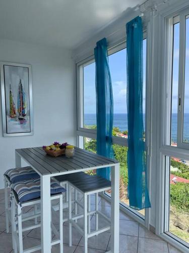 a table and chairs in a room with a view of the ocean at l'escale des roches gravées in Trois-Rivières