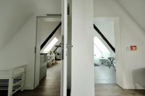 a hallway leading to a kitchen and a living room with white walls at Hausdeich in Hamburg