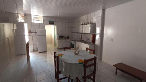 a kitchen with a table and a kitchen with a refrigerator at Estalagem Alejandro in Cunha