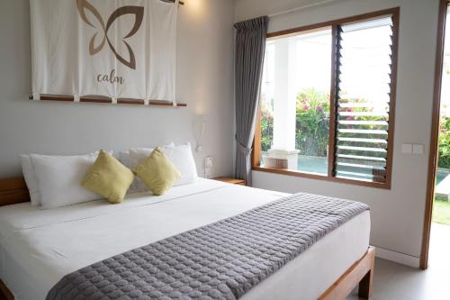 Bali Harmony Retreat في تشانغو: غرفة نوم بسرير كبير ونافذة