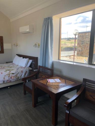 a hotel room with a bed and a table and a window at Hatchers Richmond Manor in Richmond