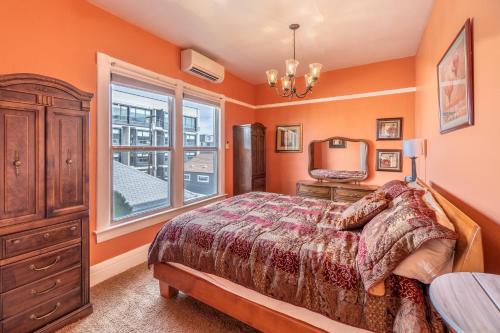 a bedroom with orange walls and a bed and a window at Rustic 2-Bedroom walking distance to Downtown in Reno