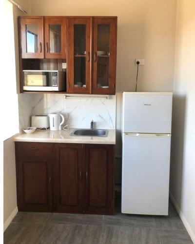 a kitchen with a white refrigerator and wooden cabinets at Hatchers Richmond Manor in Richmond