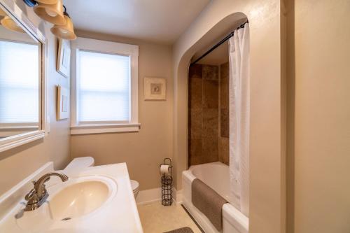 a white bathroom with a sink and a bath tub at Rustic 2-Bedroom walking distance to Downtown in Reno
