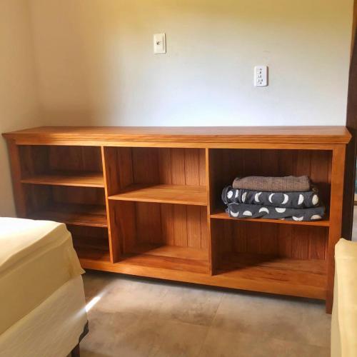 a wooden book shelf in a bedroom at Vila Verde Chalés-Serro in Sêrro