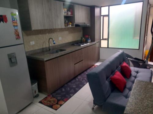 a living room with a blue couch in a kitchen at Linda habitación amplia iluminada Bogota Calle 80 in Bogotá