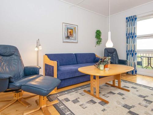 a living room with a blue couch and a table at 6 person holiday home in H jer in Højer