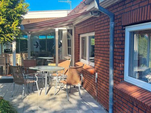 a patio with a table and chairs on a brick wall at 6 person holiday home in Dannemare in Nakskov