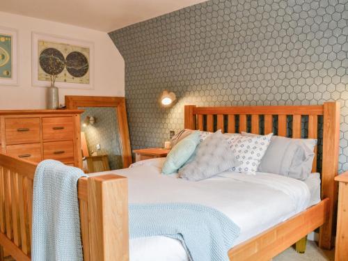 a bedroom with a wooden bed and a dresser at 1 The Courtyard in Kinneff