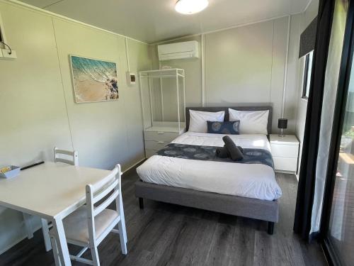 um pequeno quarto com uma cama e uma mesa em Marlo Caravan Park & Motel em Marlo