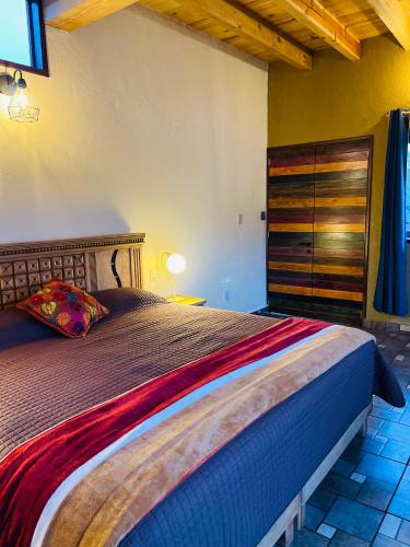 a bedroom with a large bed and a wooden dresser at Ma Petite Maison in Tepoztlán