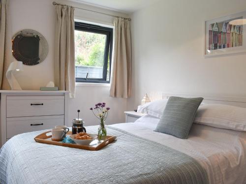 a bedroom with a tray of food on a bed at Priory Barn in Freshwater