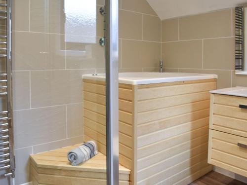 een badkamer met een douche, een bad en een wastafel bij Priory Barn in Freshwater