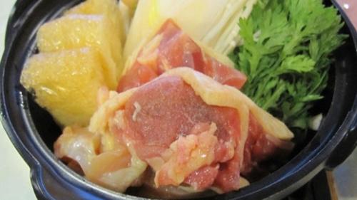 a black bowl of food with meat and vegetables at Kyukamura Nyuto-Onsenkyo in Senboku