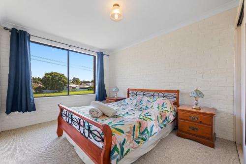 a bedroom with a bed and a large window at Apollo Unit 14 1st Floor in Narooma