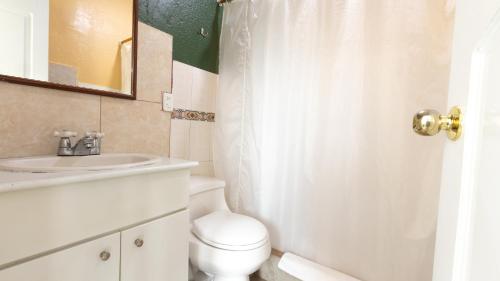 a bathroom with a white toilet and a sink at Hotel Miraflores in Ibarra