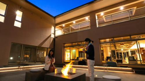 a man and a woman standing in front of a building at Kyukamura Kesennuma-Ohshima in Kesennuma