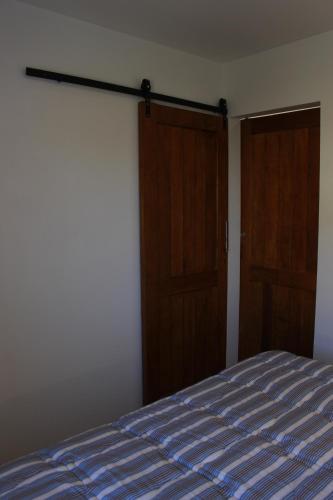 a bedroom with a bed and two wooden doors at Meraki Lofts in El Chalten