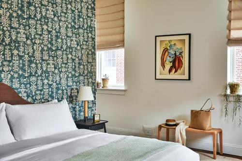 a bedroom with a bed with a blue and white wallpaper at The Pinch Charleston in Charleston