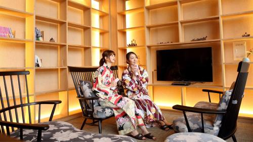 twee vrouwen in schommelstoelen in een kamer bij Kyukamura Shonai-Haguro in Tsuruoka