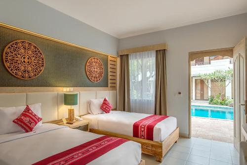 a hotel room with two beds and a pool at Baleka Resort & Spa in Legian