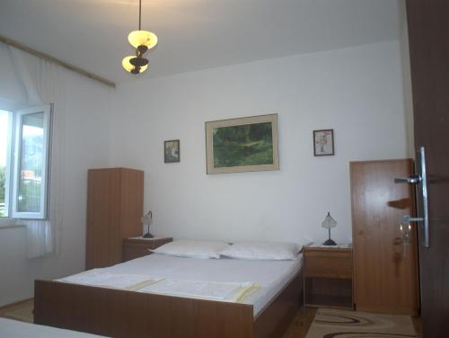 a bedroom with a large bed and a window at Apartments RUDO in Podaca